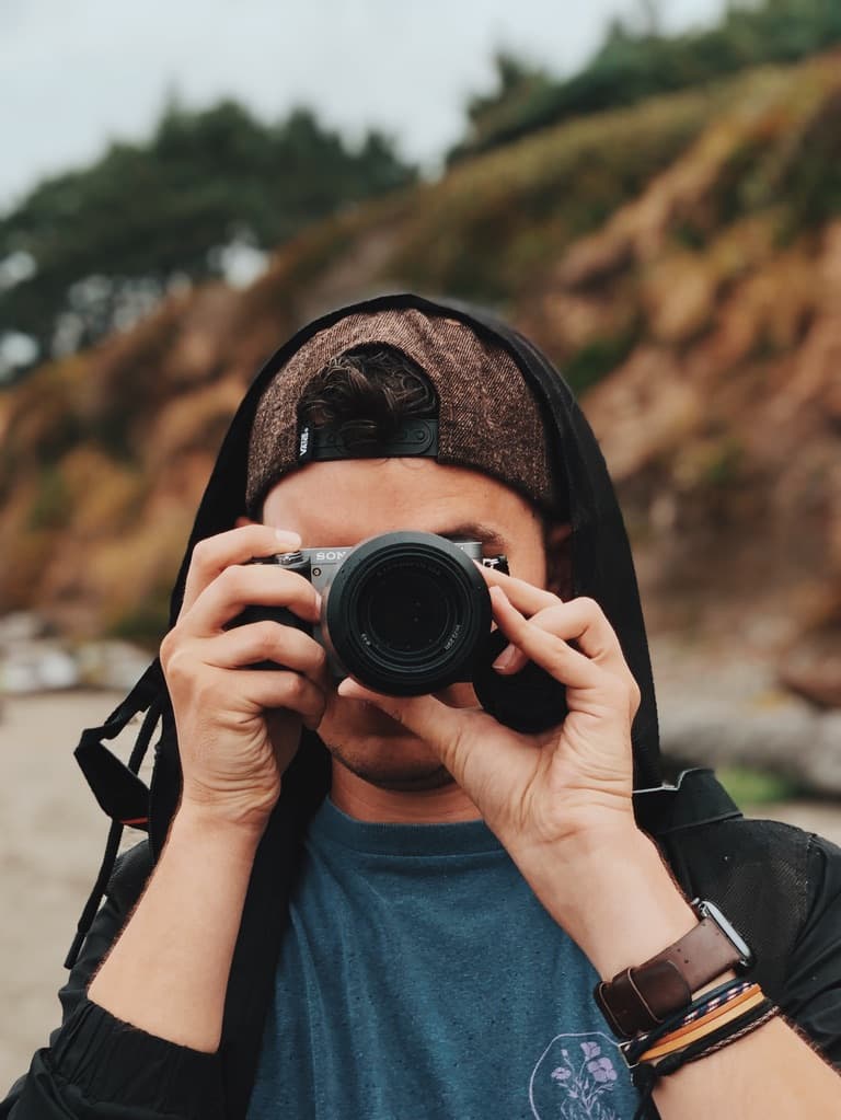 Portrait of Casey taking a picture with a camera.