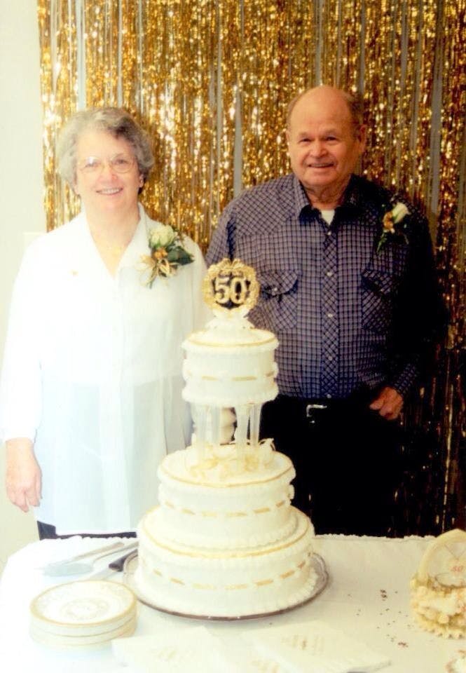 Casey's grandparents standing in front of their 50th anniversary cake.