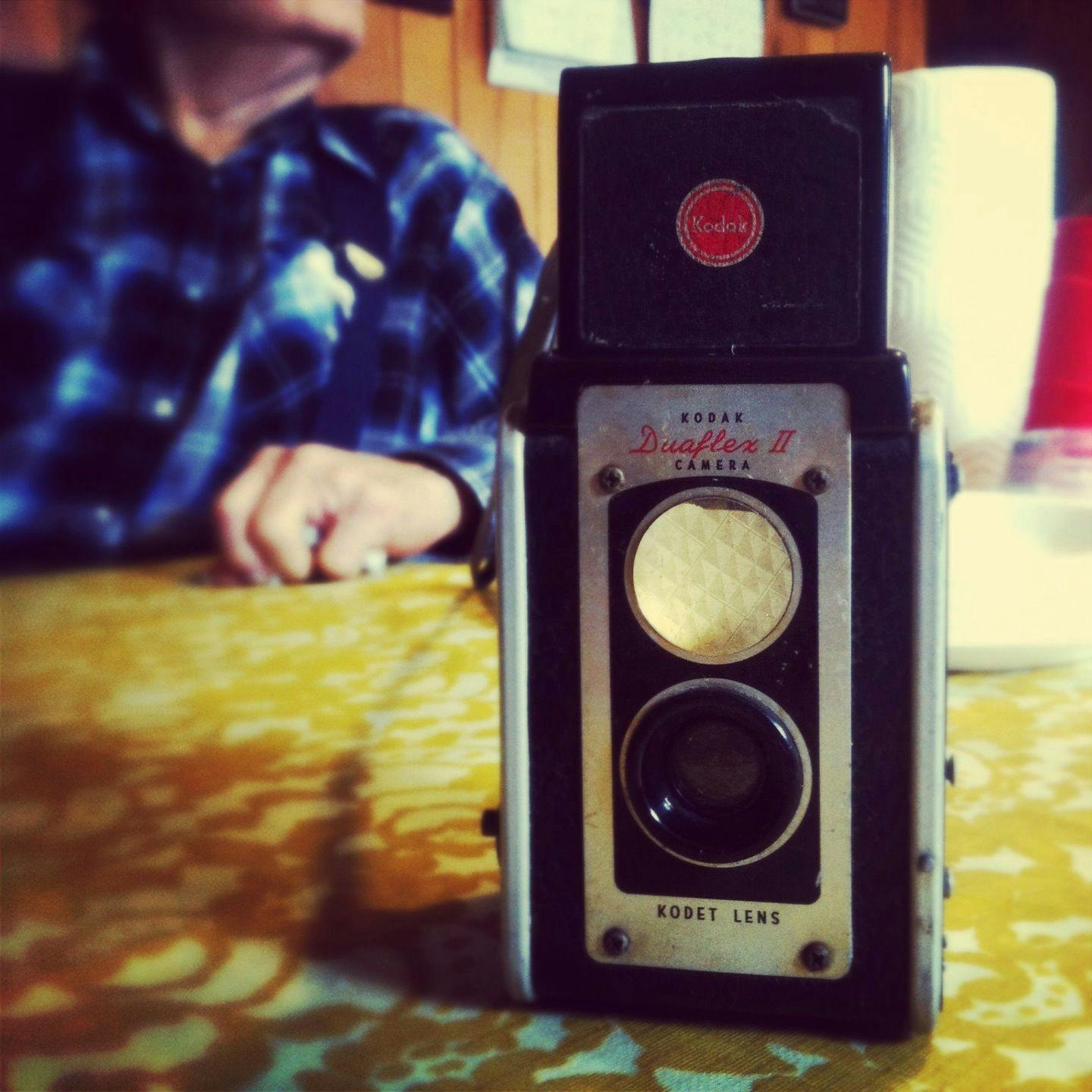 A vintage Kodak camera placed on a dining table, with Casey's grandpa
sitting in the background.